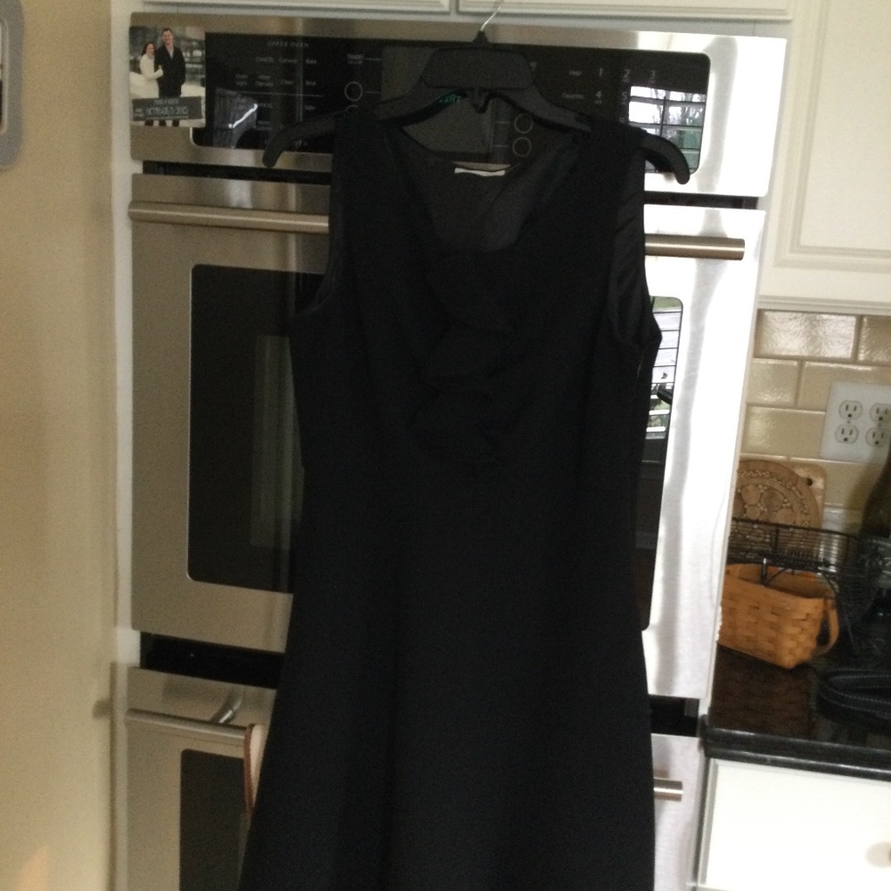 Size 12 petite Calvin Klein black crepe dress with ruffle detail at neck.